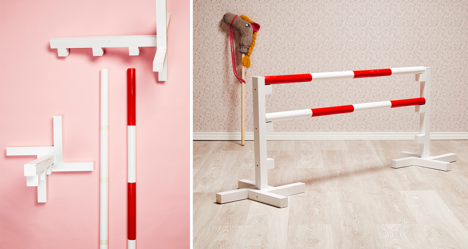 Sisätiloissa valkoiset puutolpat punavalkoraidoilla, keppihevonen kukkakuvioisella taustalla