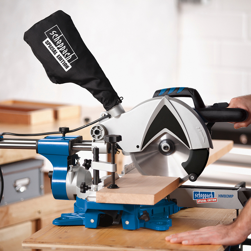 Sininen ja harmaa jiirisaha leikkaa vaaleaa puulistaa puupöydällä verstastilassa.