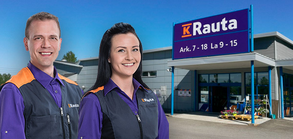 K-Raudan siniharmaa liikerakennus aukioloajoilla kyltissä, kaksi työntekijää violeteissa liiveissä.