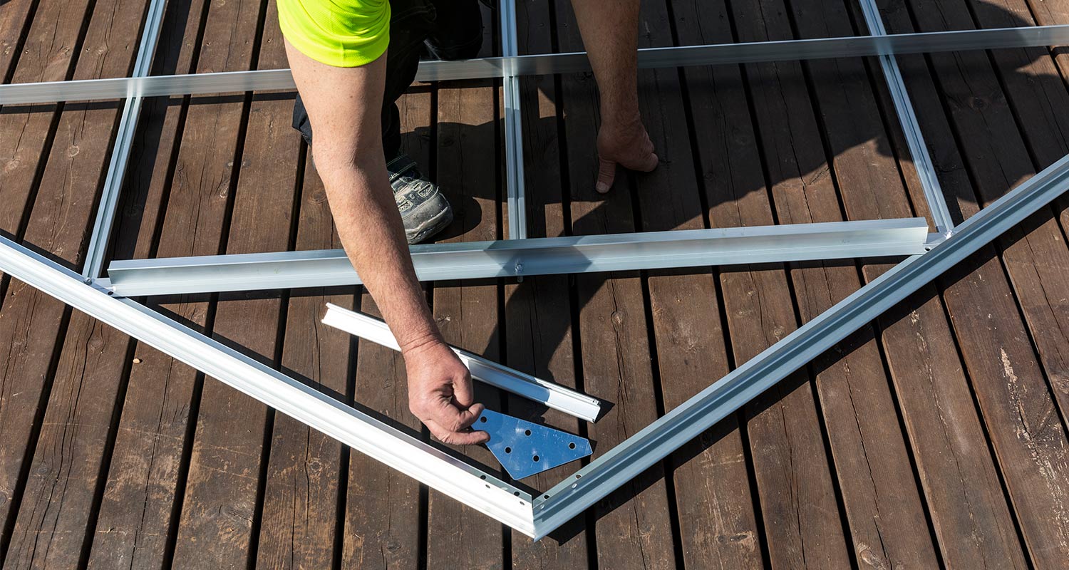 Mies kasaa kasvihuonetta kesäisenä päivänä.