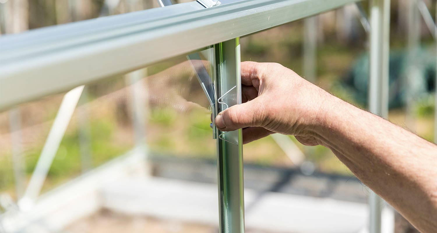 Mies kasaamassa kasvihuonetta K-Raudan ohjeilla.