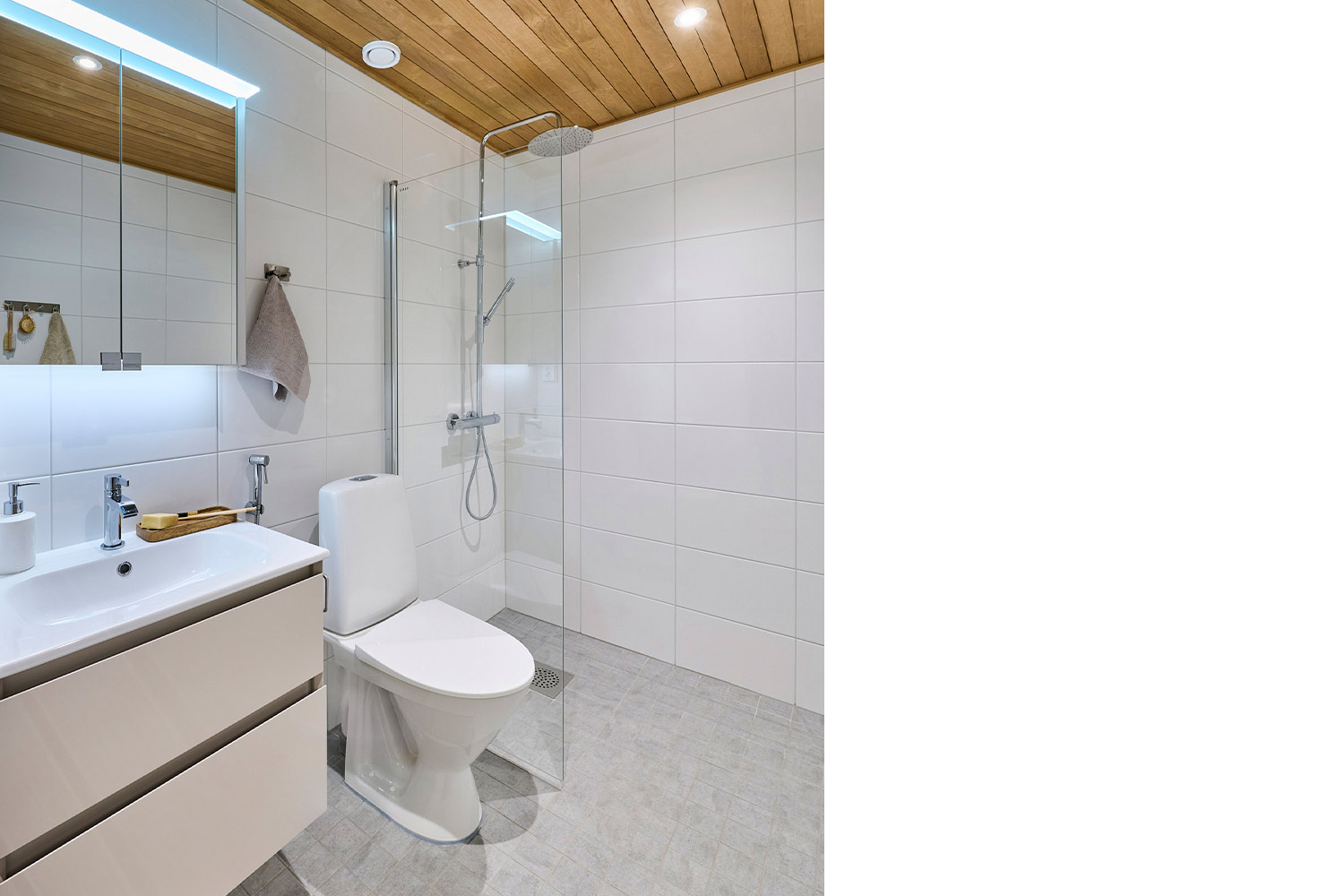 Greigen sävyinen allaskaappi Cello Bay-sarjasta tuo neutraaliin kylpyhuoneeseen lämpöä. Kuvan pintamateriaalit K-Raudan valikoimista.