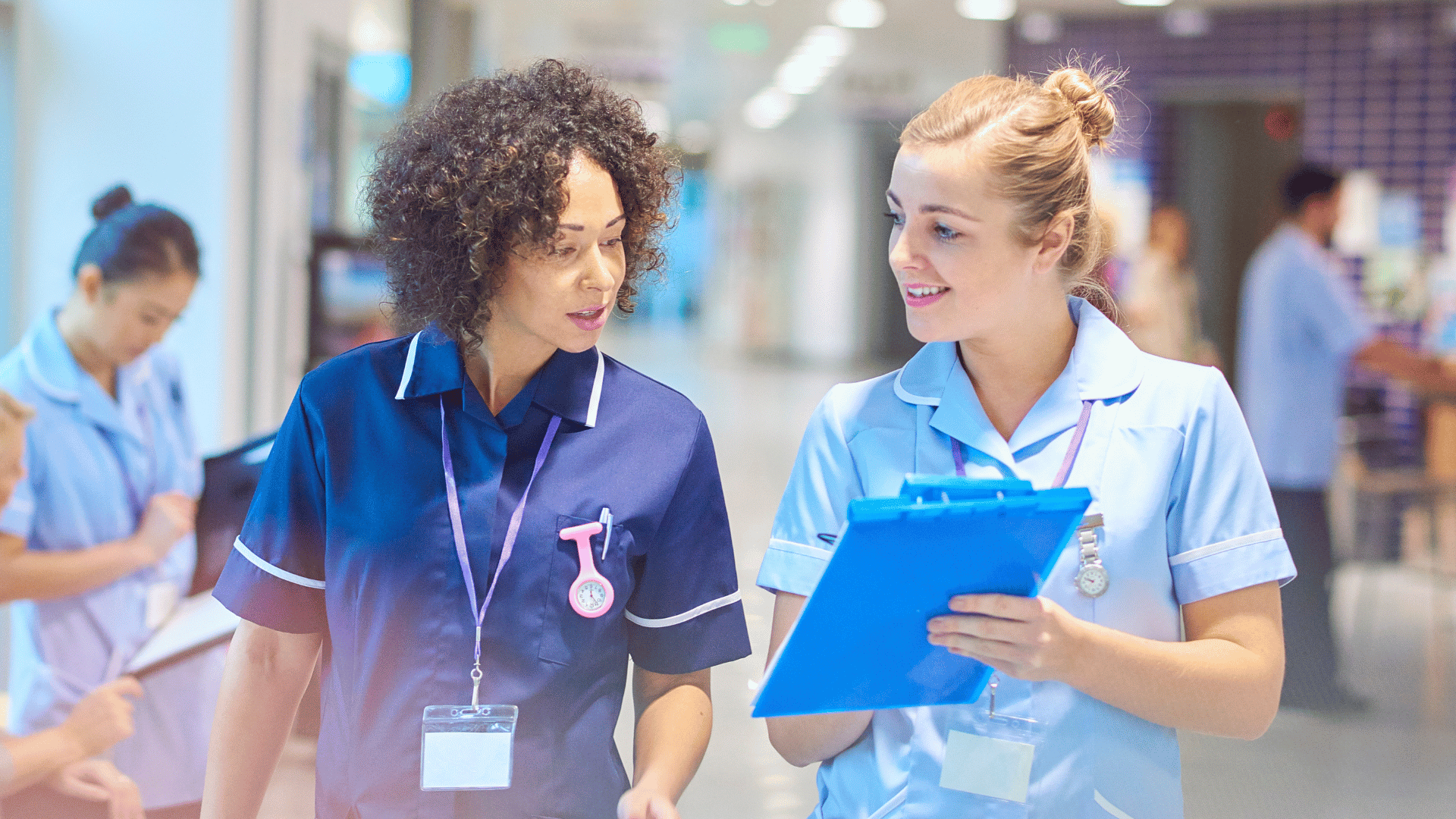 Nurse mentor and Gen Z mentee walking through a hospital hallway, demonstrating modern nursing mentorship with real-time support, peer coaching, and collaborative learning in a clinical setting.