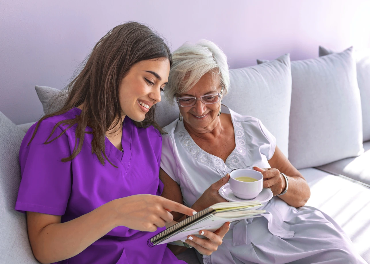 LatinX female nurse assists elderly patient at home.