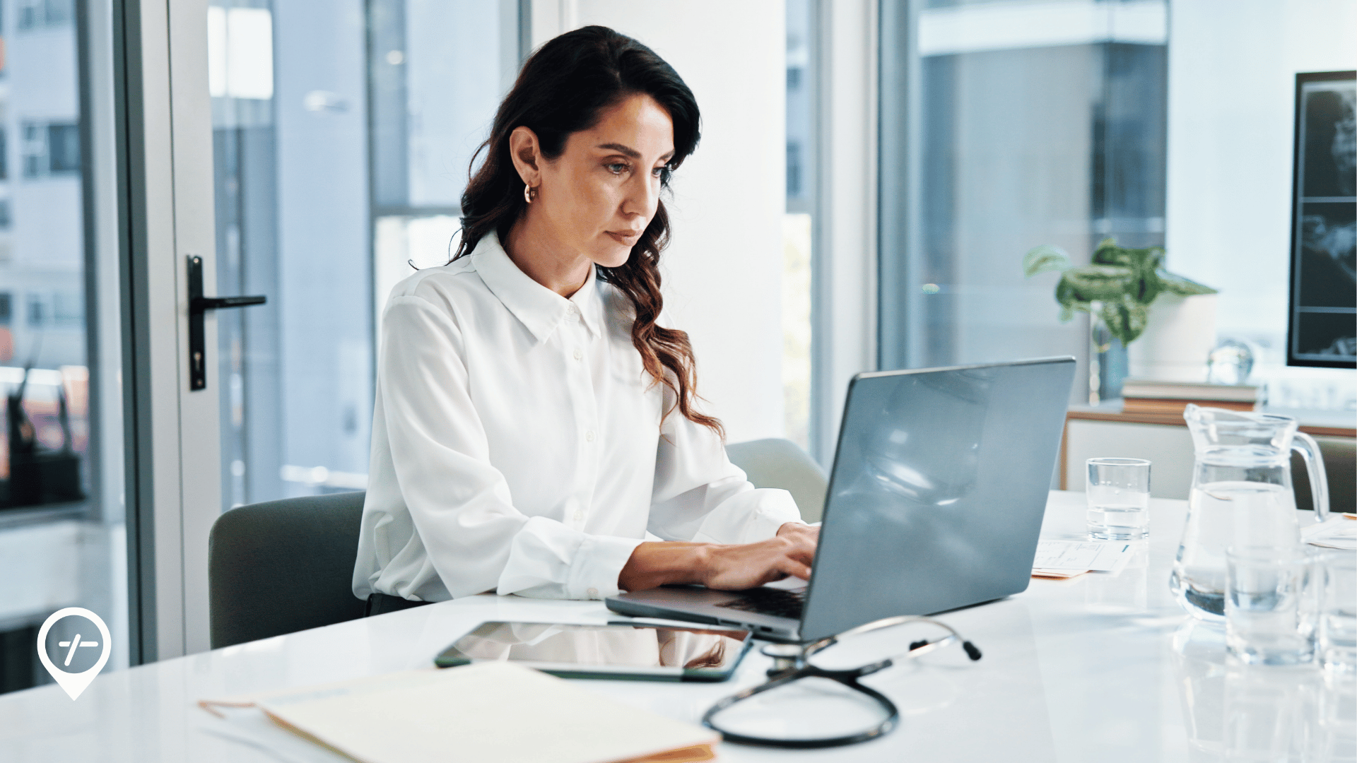 Chief Nursing Officer reviewing healthcare workforce metrics and operational performance data on a computer dashboard in a hospital office