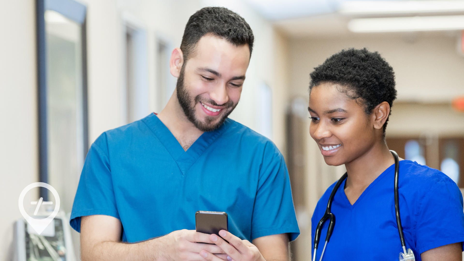 A male nurse shows a female nurse a nursing jobs app on his phone.