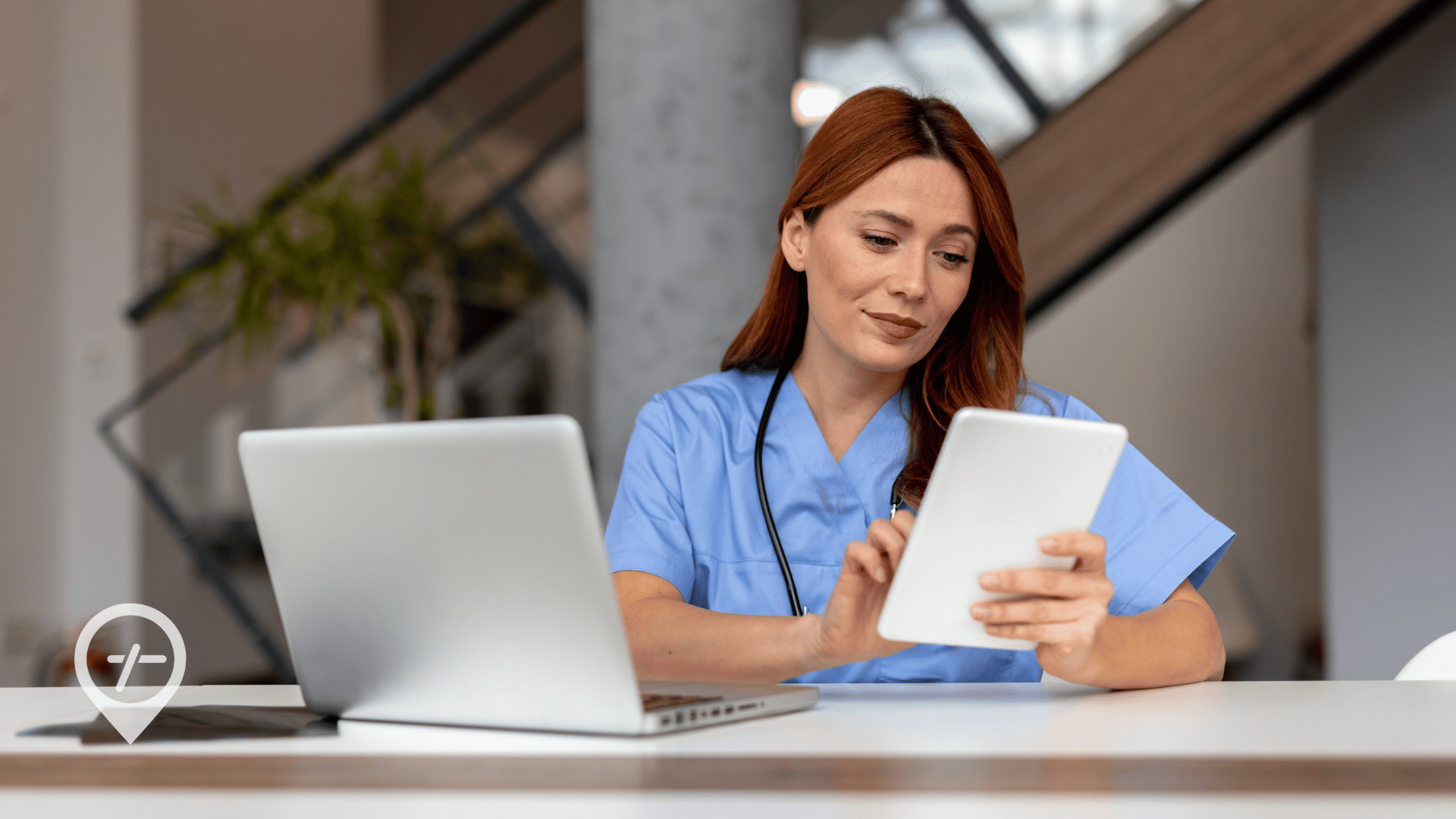 An image of a nurse standing at a hospital nursing station looking at scheduling gaps on a tablet.