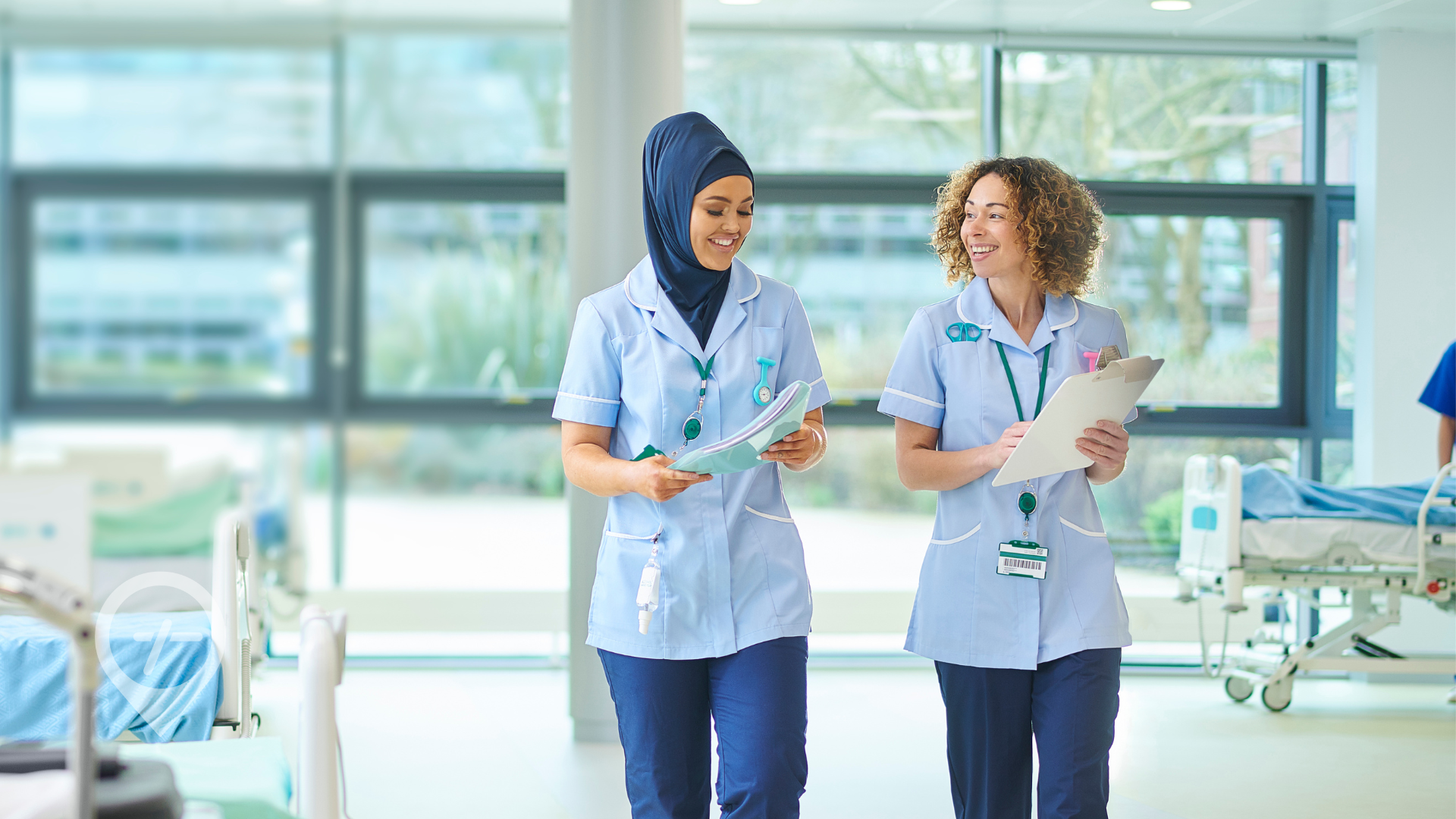 Nurse mentor and nurse mentee walking in a clinical setting.