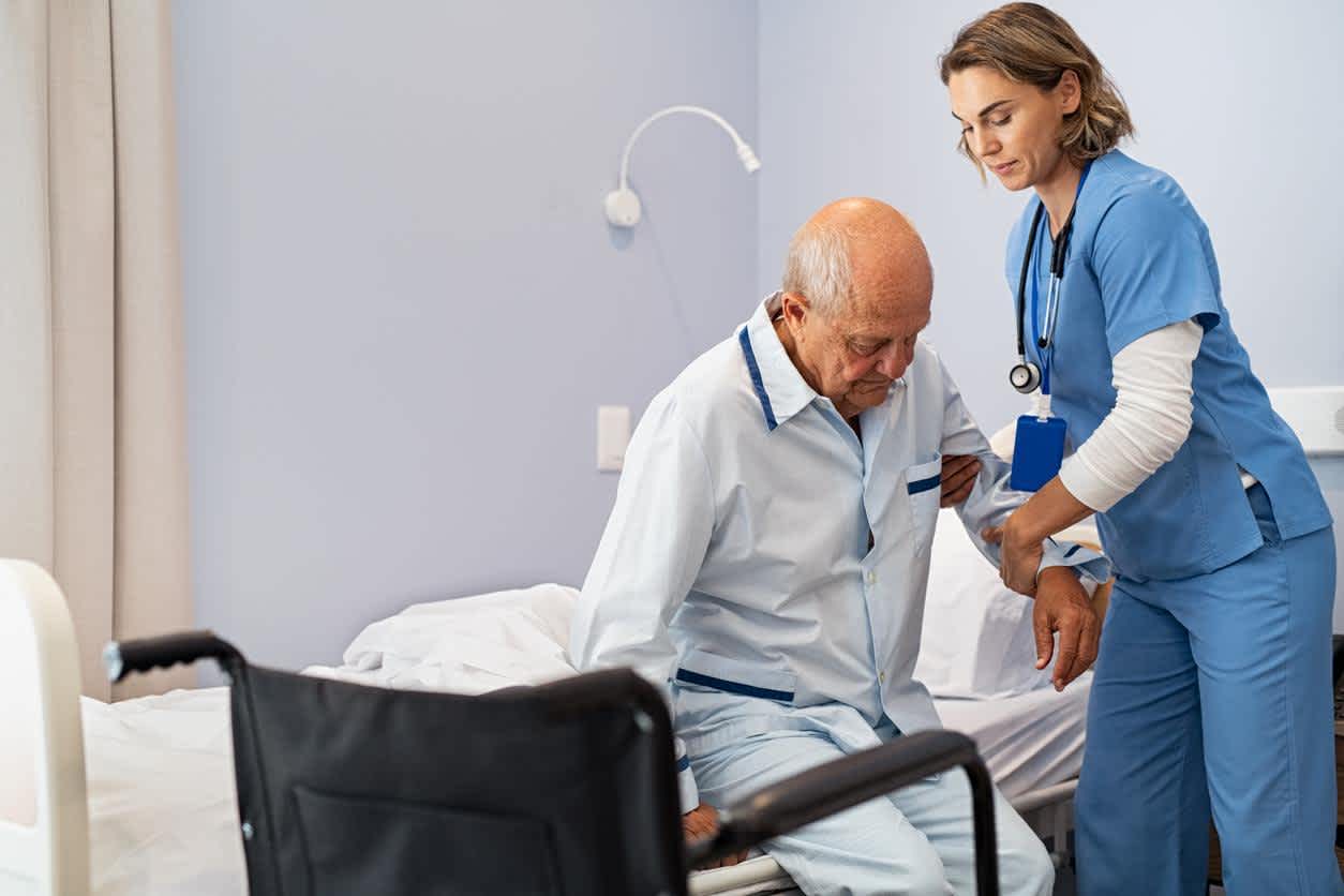 Hospice nurse helping patient stand up
