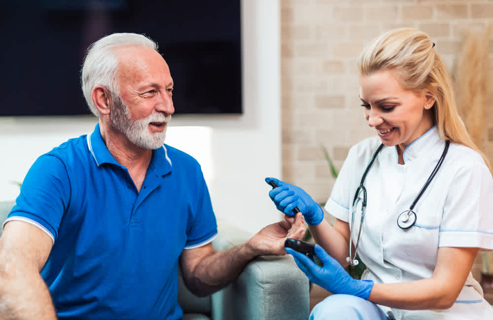 Home health nurse helping male patient at home