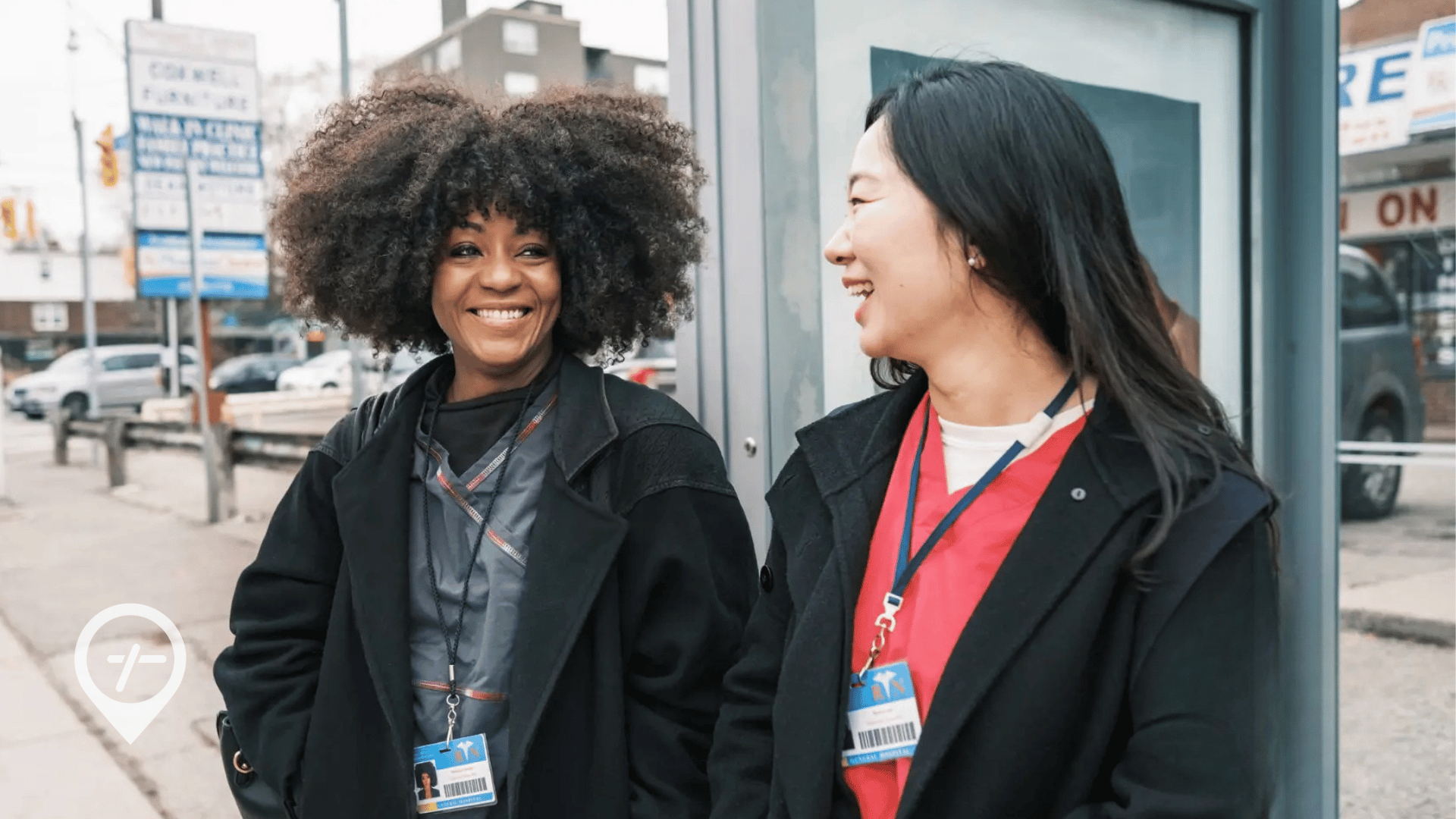 Two nurses at a bus stop, illustrating the advantages of seasonal staffing with local W-2 nurses over costly travel nursing contracts.