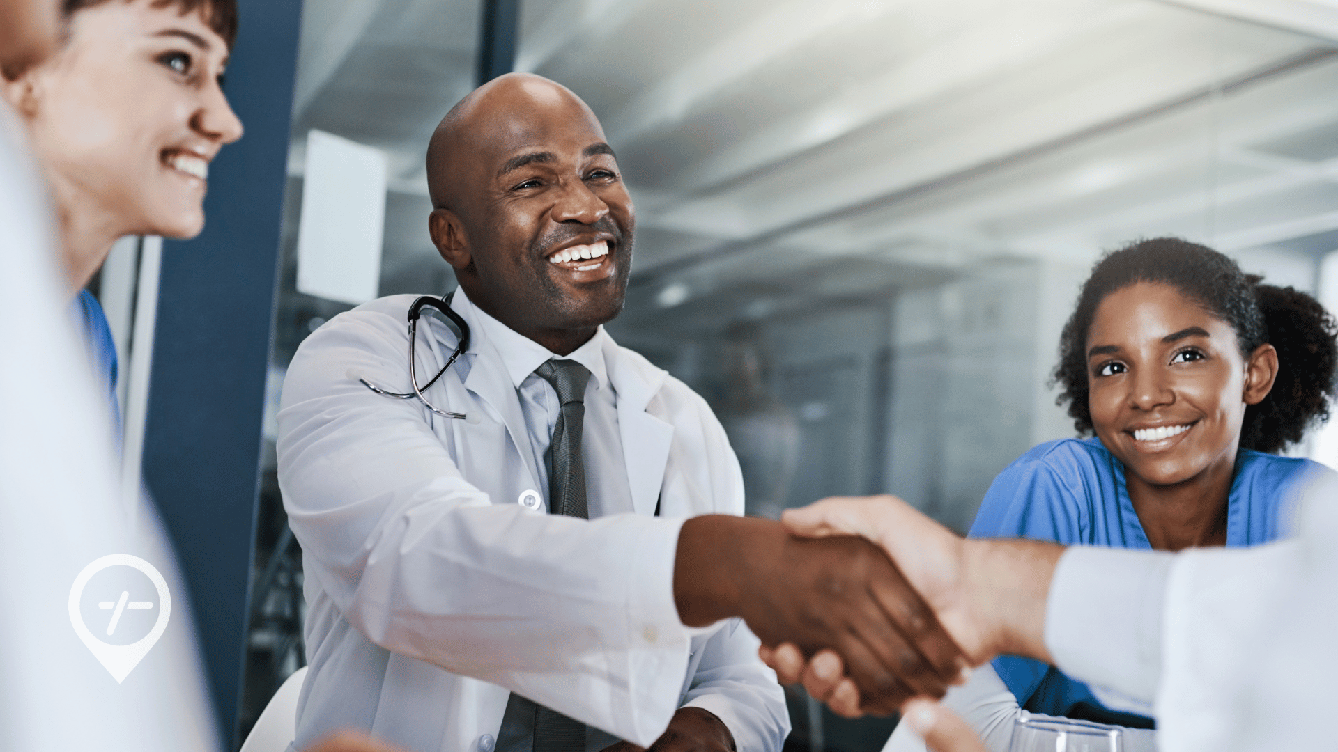 A group of nurses, doctors, and executives shaking hands after a meeting.