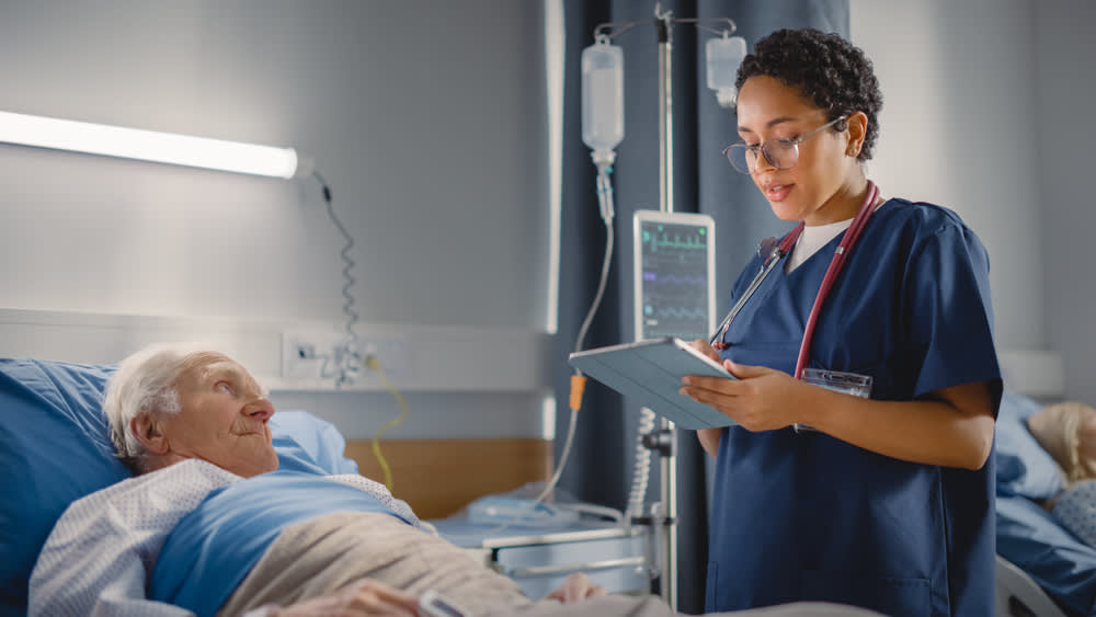 Telemetry nurse monitoring an elderly patient