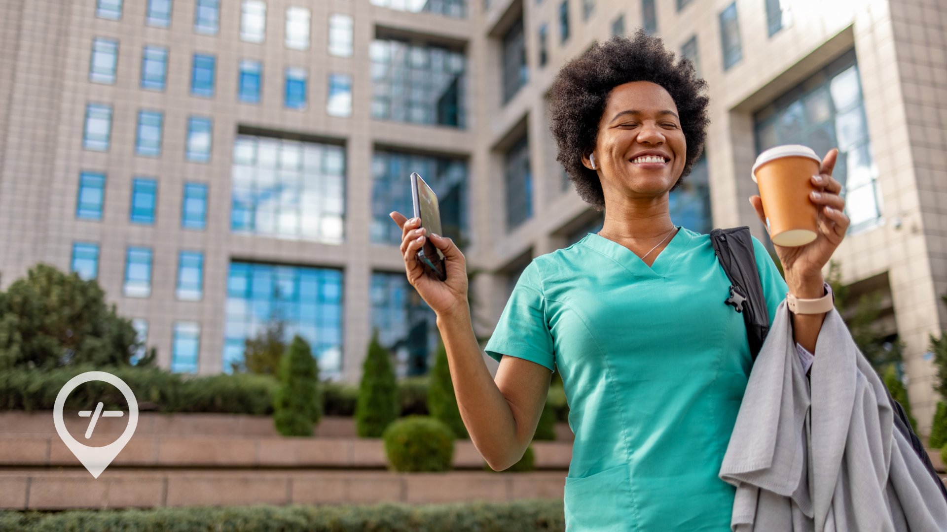A nurse leaves work with a coffee in hand and a smile on her face.