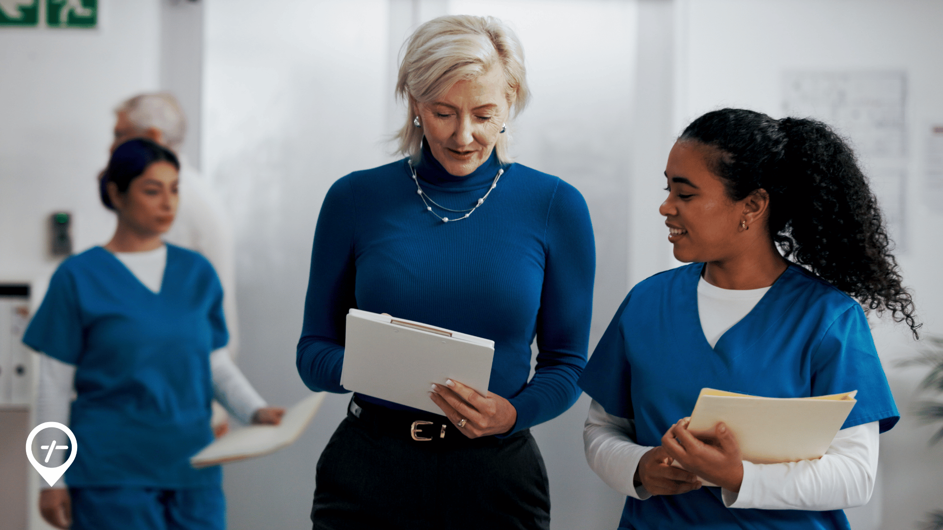 Chief nursing officer walking with nurses in a hospital while overseeing clinical operations and healthcare workforce management.