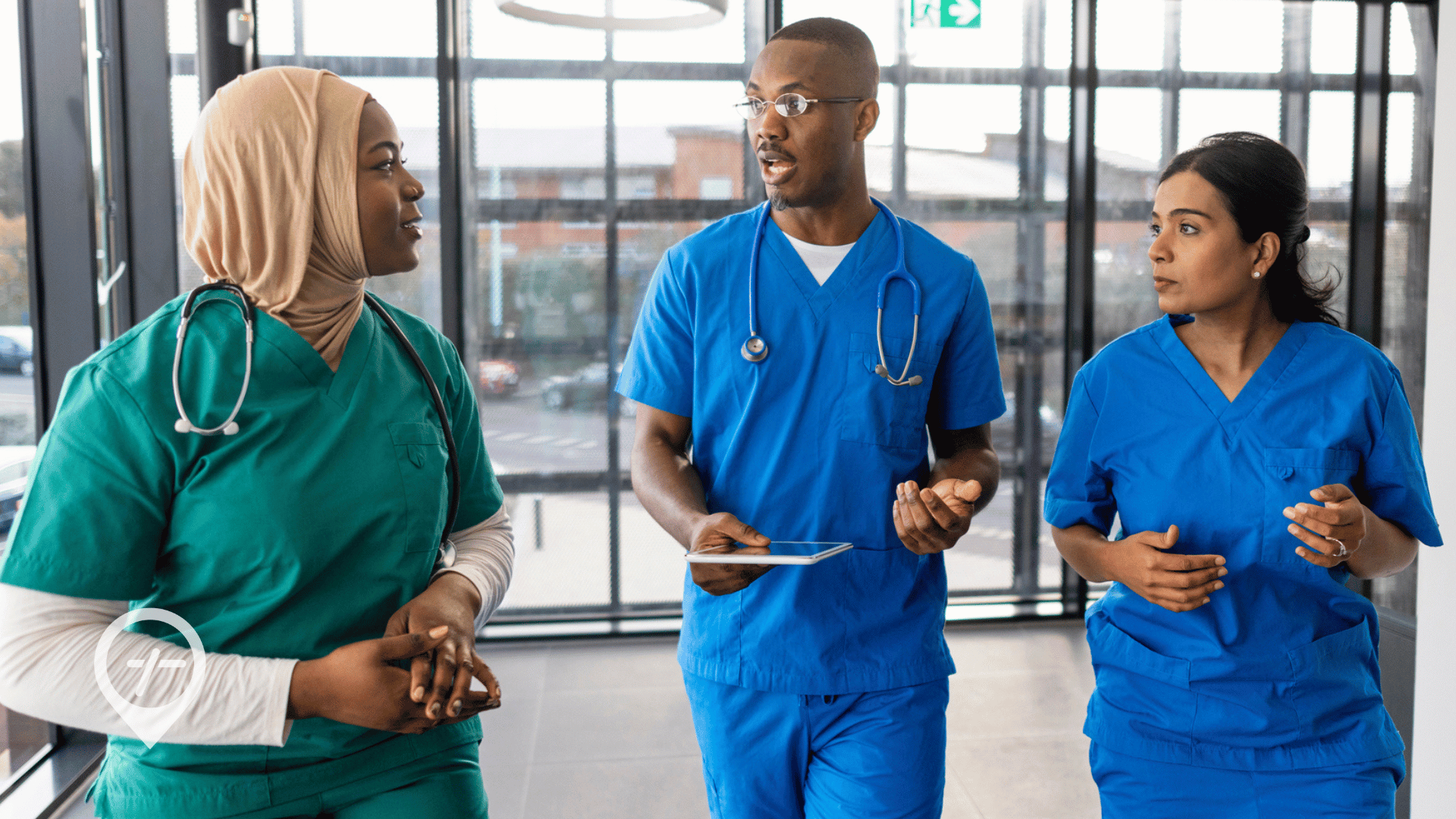 An image of nurses walking down the hall of a hospital and talking.