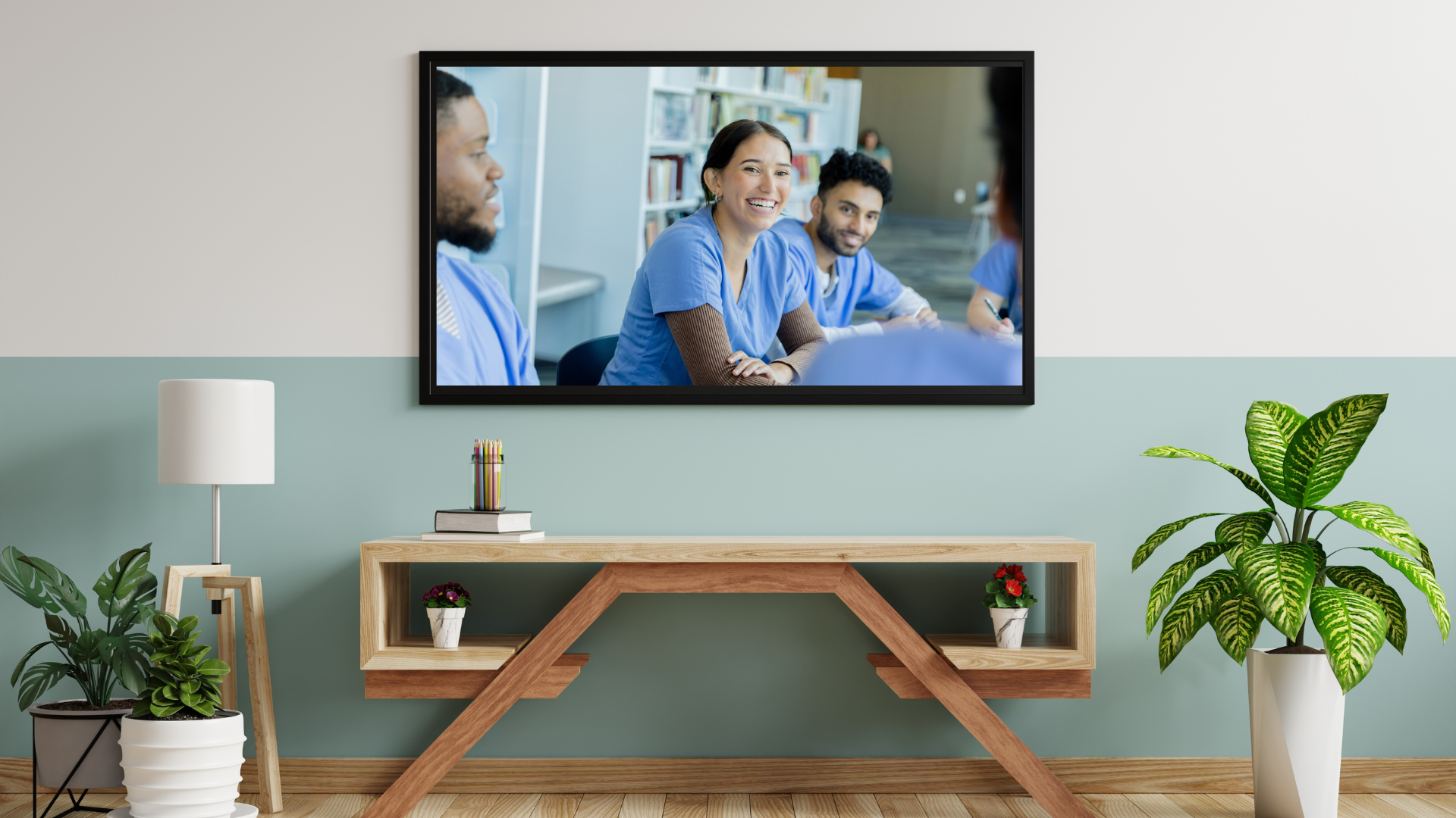 A flat-screen TV in a living room with nurses collaborating on the screen. 