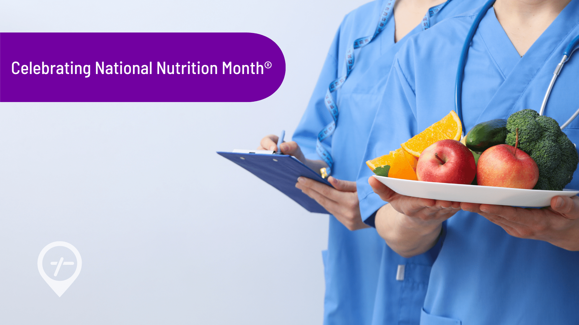 A nurse holds a plate of fruits and vegetables while another holds a clipboard in celebration of National Nutrition Month.
