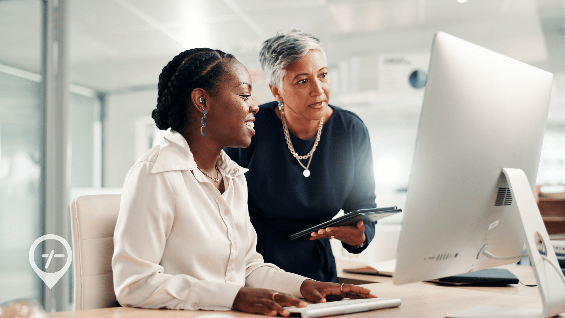 Chief Nursing Officer and nursing supervisor reviewing workforce data on a computer screen to optimize hospital staffing and patient care.