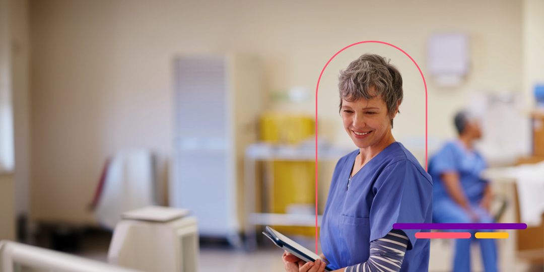 Nurse smiling and holding a tablet.