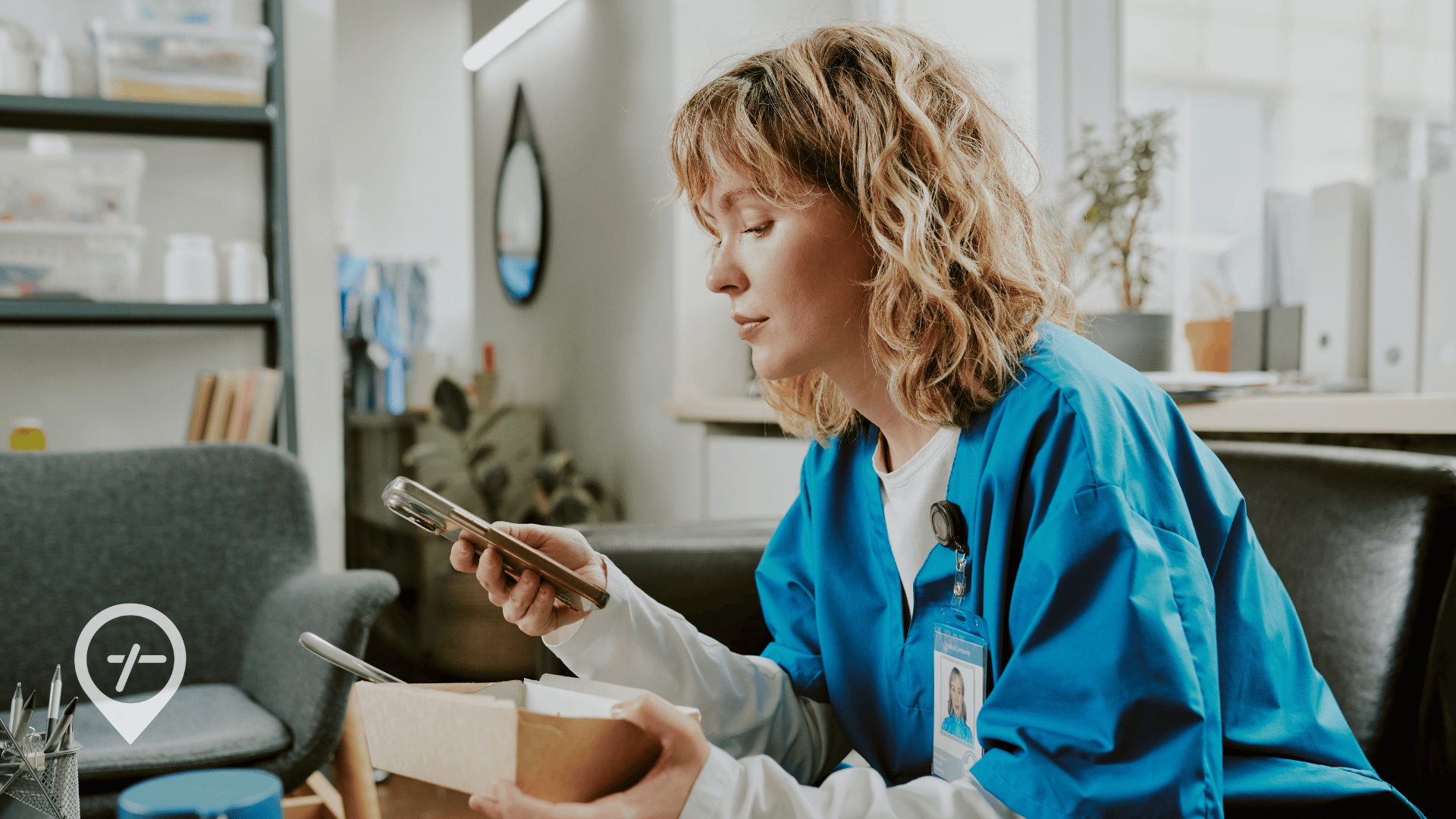 A nurse sits on a couch eating her lunch and checking her credential status on her phone.
