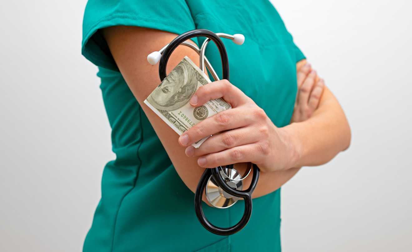 A registered nurse holding a stethoscope and cash, representing ShiftMed’s RN referral bonus paid through payroll.