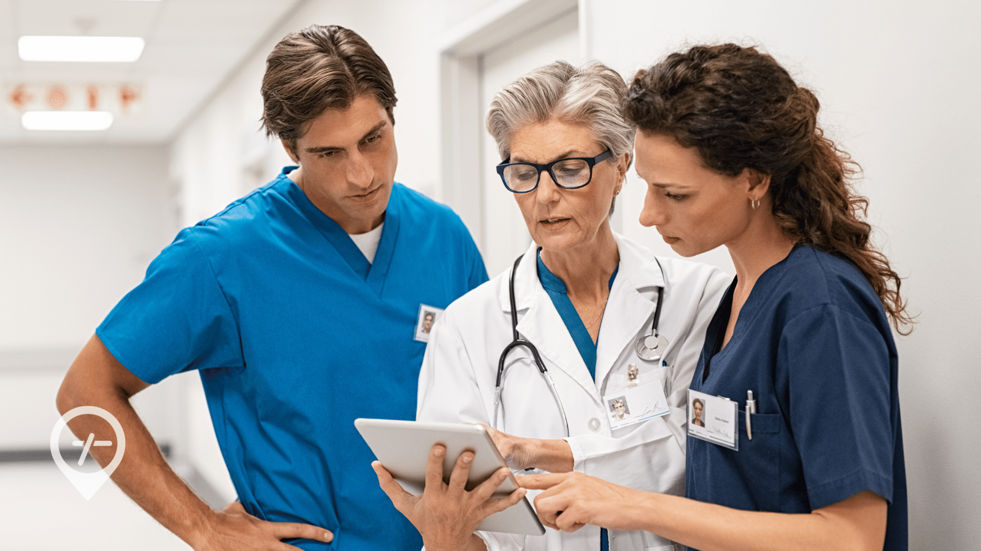 Two hospital nurses consult with a doctor on patient care coordination.