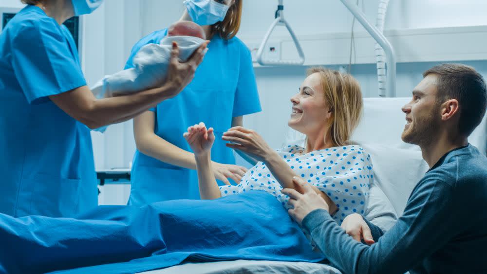 Certified nurse midwife holding a newborn baby