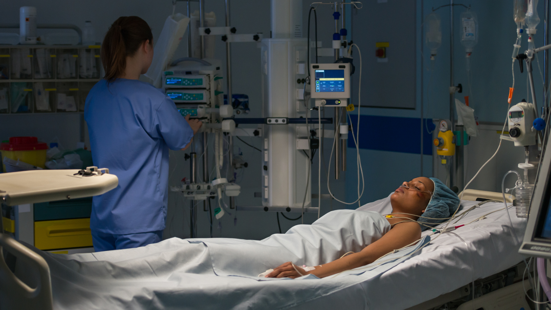 A night shift nurse monitors an injured patient's vitals.