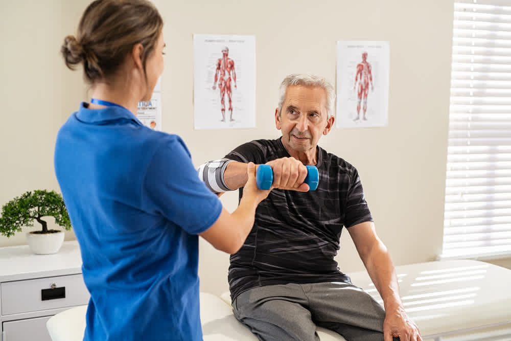 Orthopedic nurse assisting patient with exercise