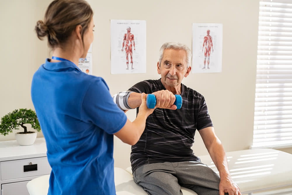 Orthopedic nurse assisting patient with exercise