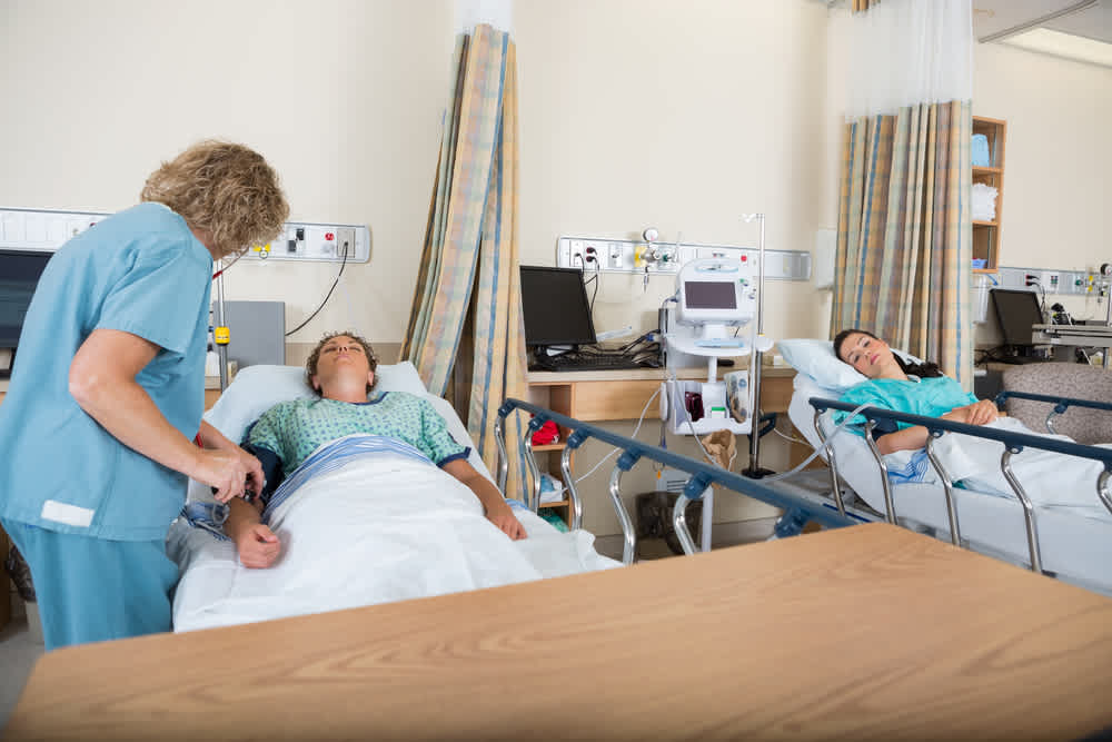 PACU nurse attending to a patient in PACU