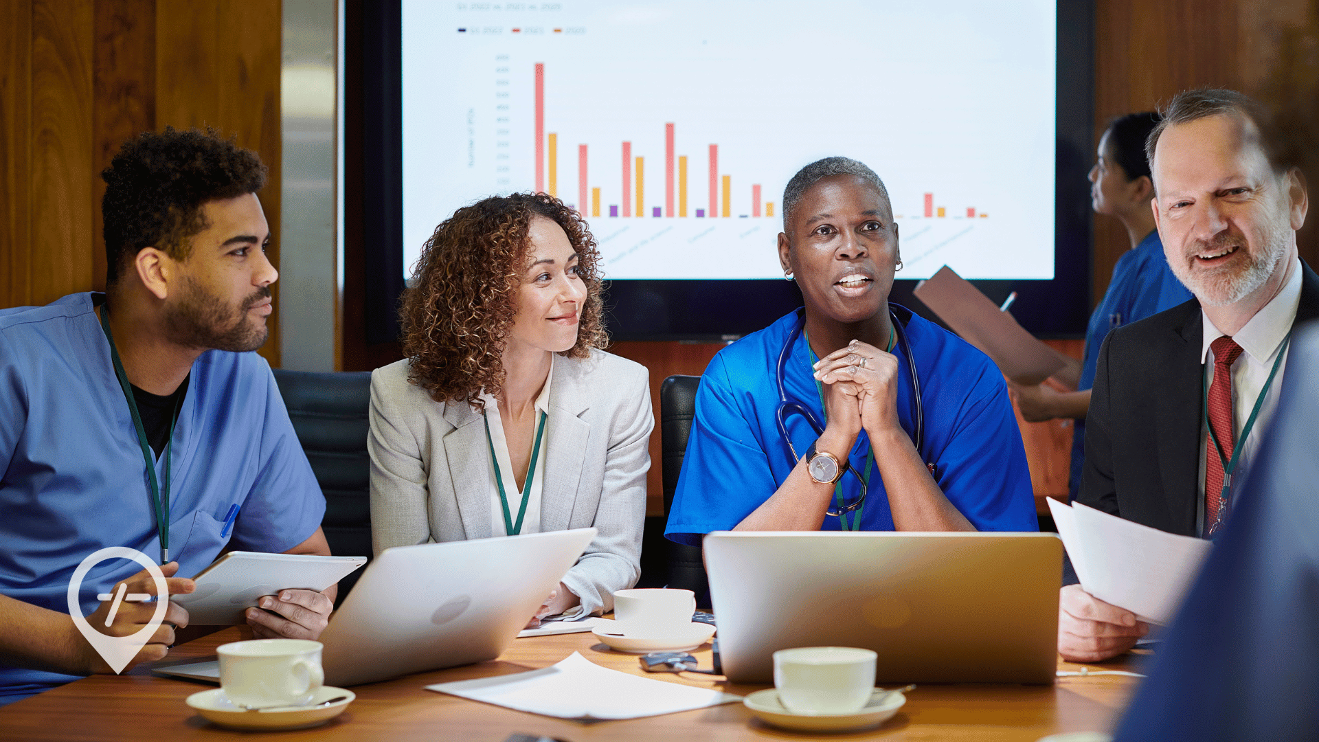 Doctors, nurses, and healthcare executives discuss healthcare staffing in a hospital boardroom.