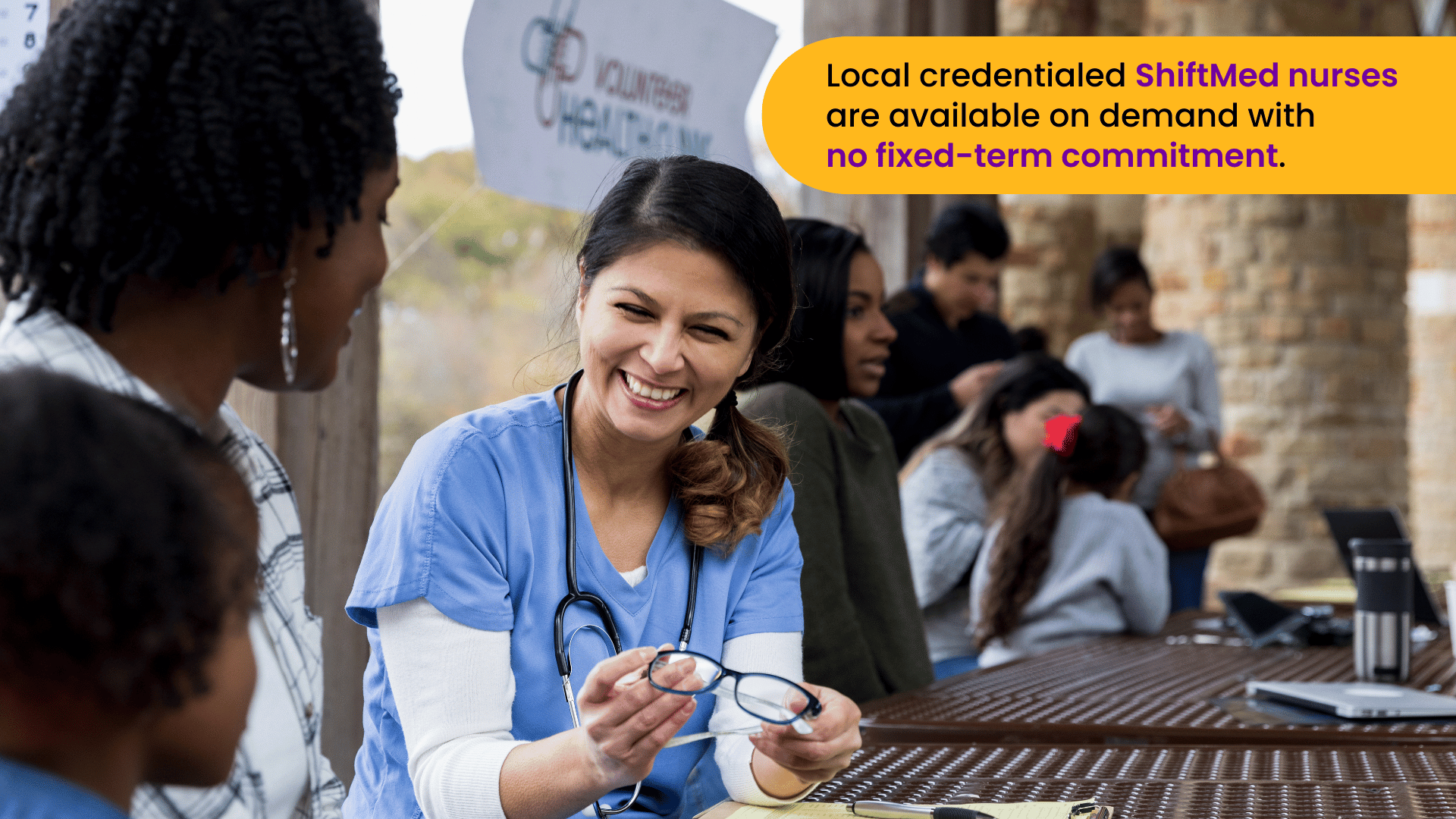 A local on-demand nurse talks to a family during a community health event.