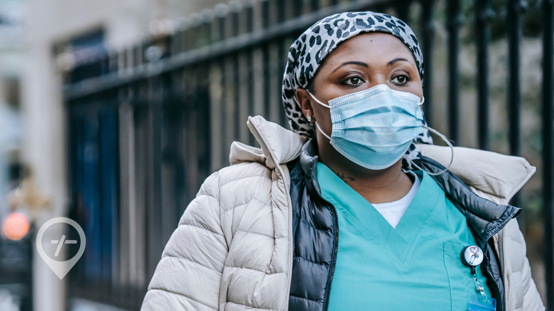 A nurse walking to work with a contemplative look on her face. 