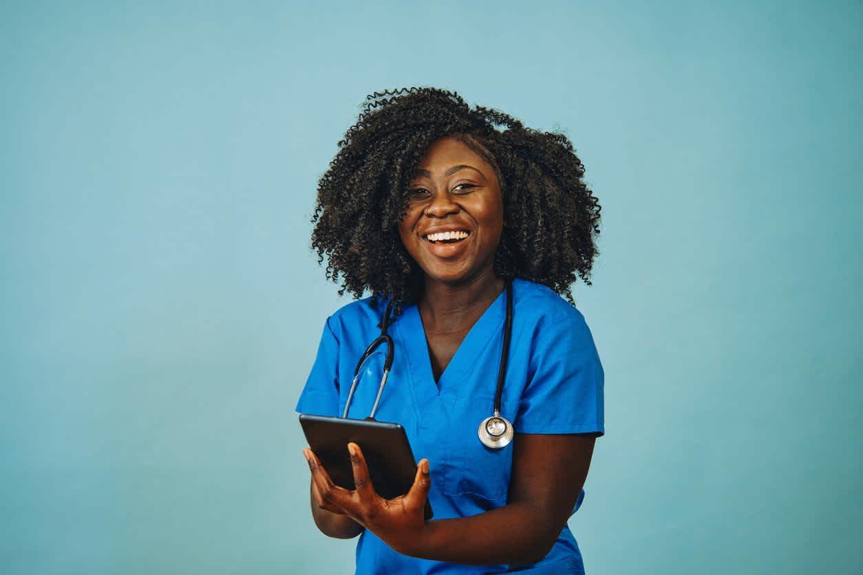 Nurse smiling while using an iPad at the hospital