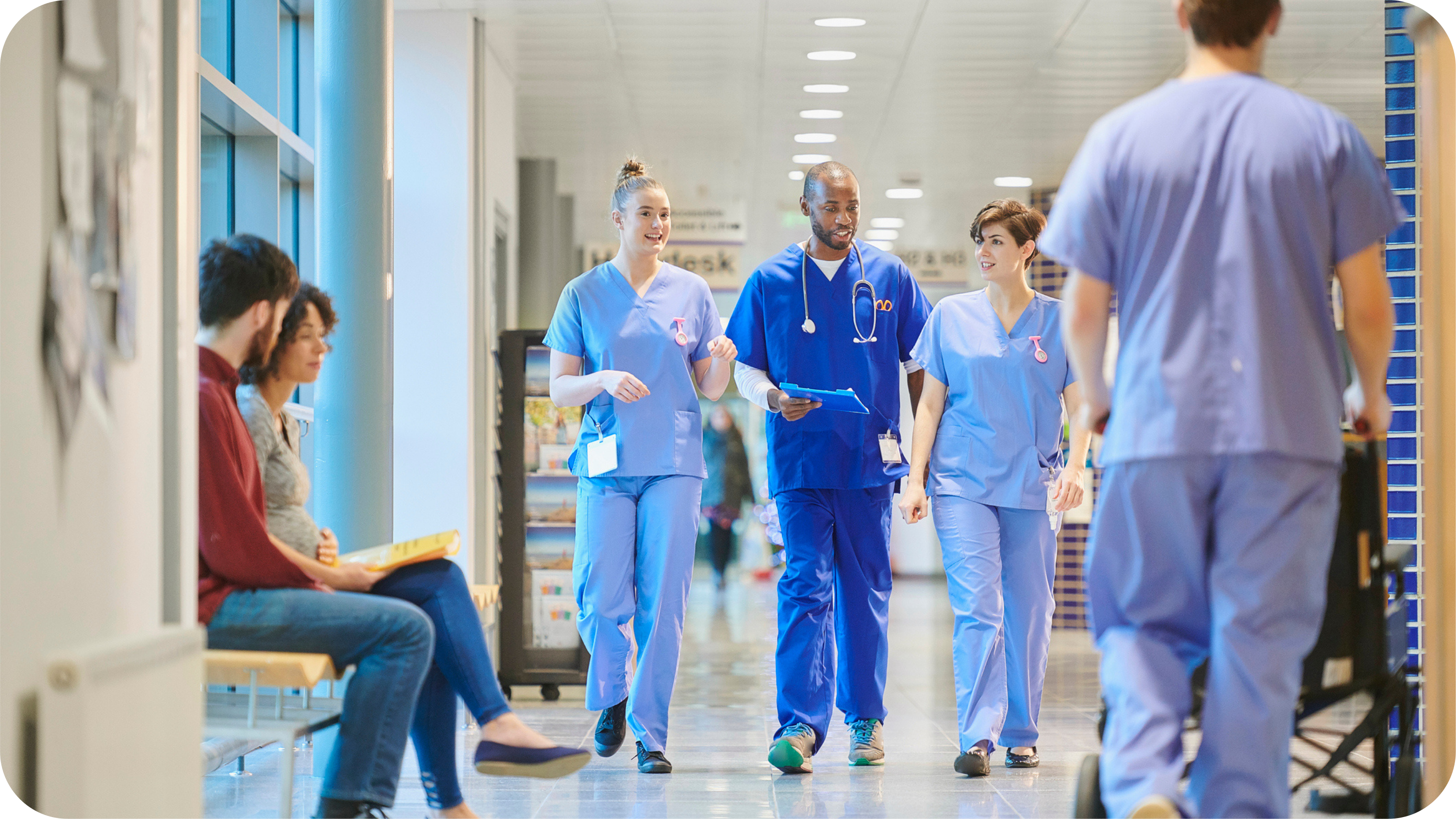 A doctor talking with two nurses while walking in a hospital.