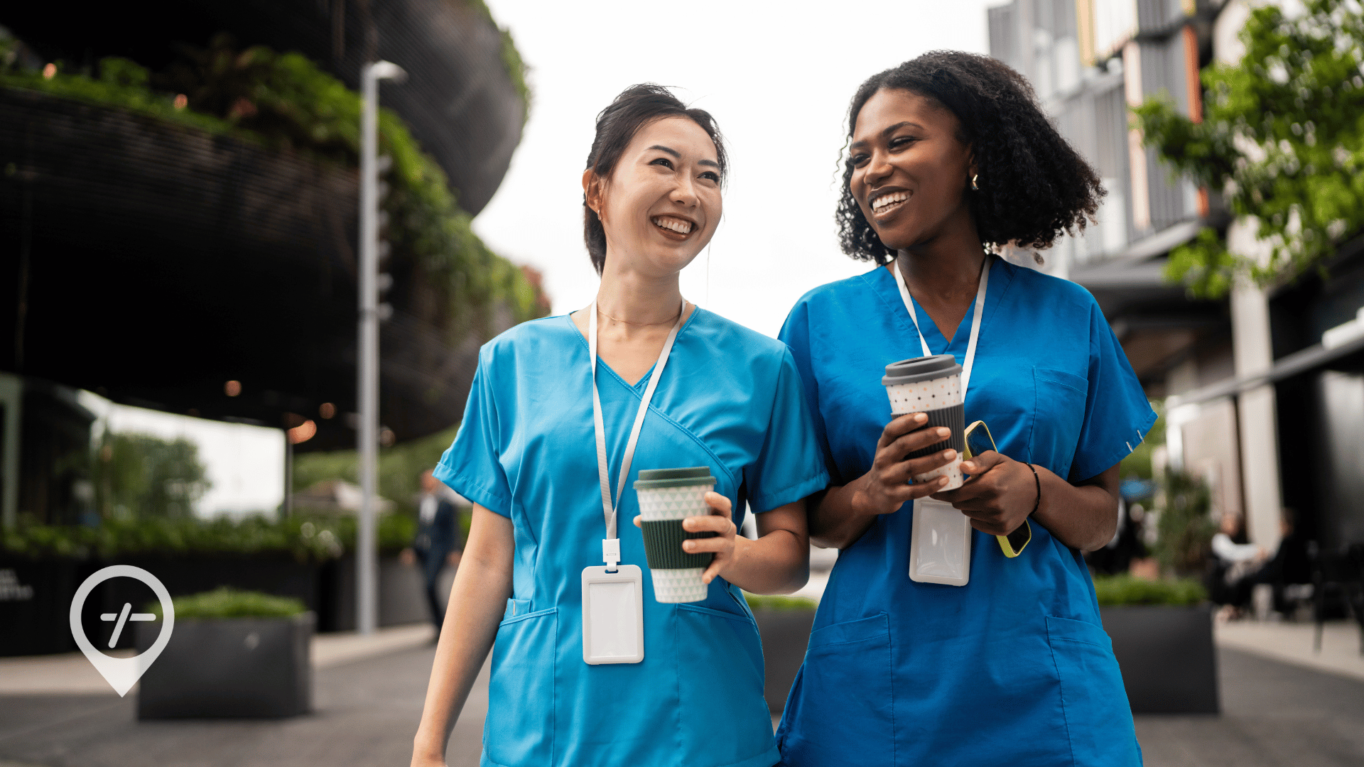 Two nurses walking and talking outside while checking schedules on their phones, illustrating flexible nurse scheduling and workforce engagement.
