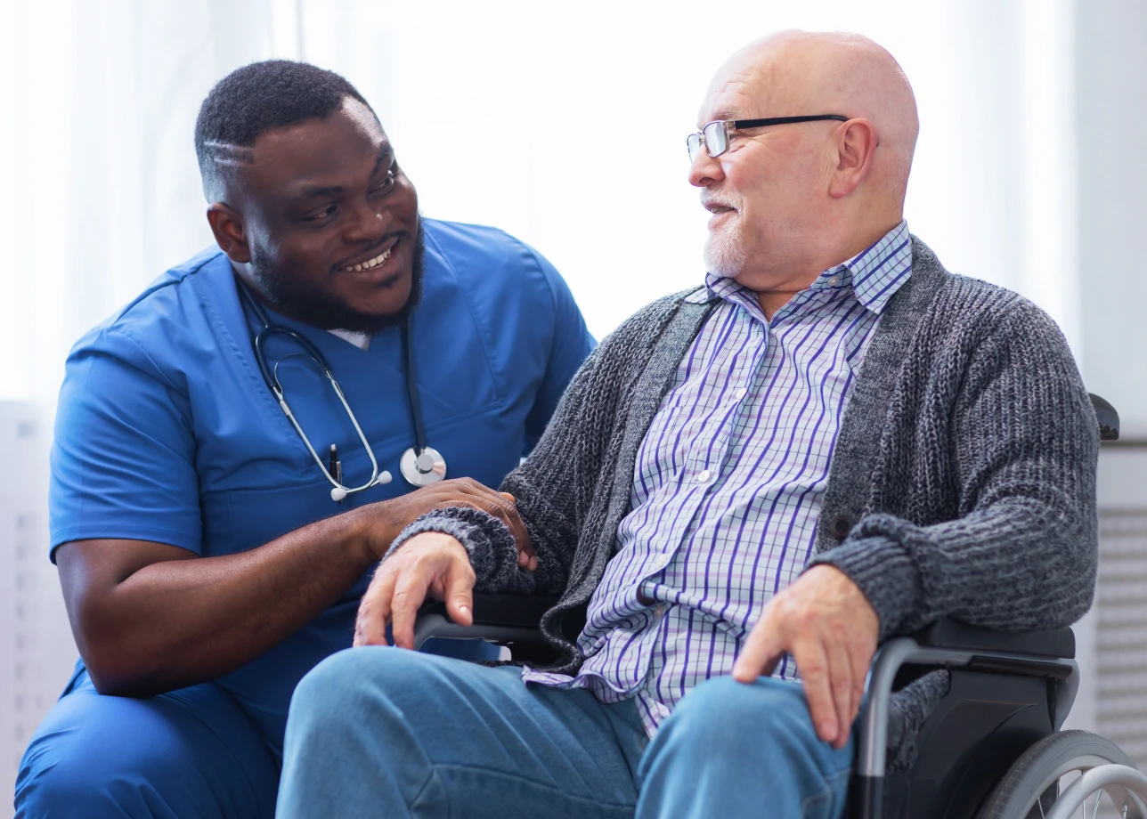 African American male LPN assists elderly patient.