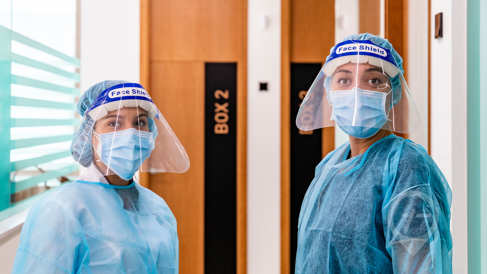 Healthcare professionals in COVID-19 protective gear.