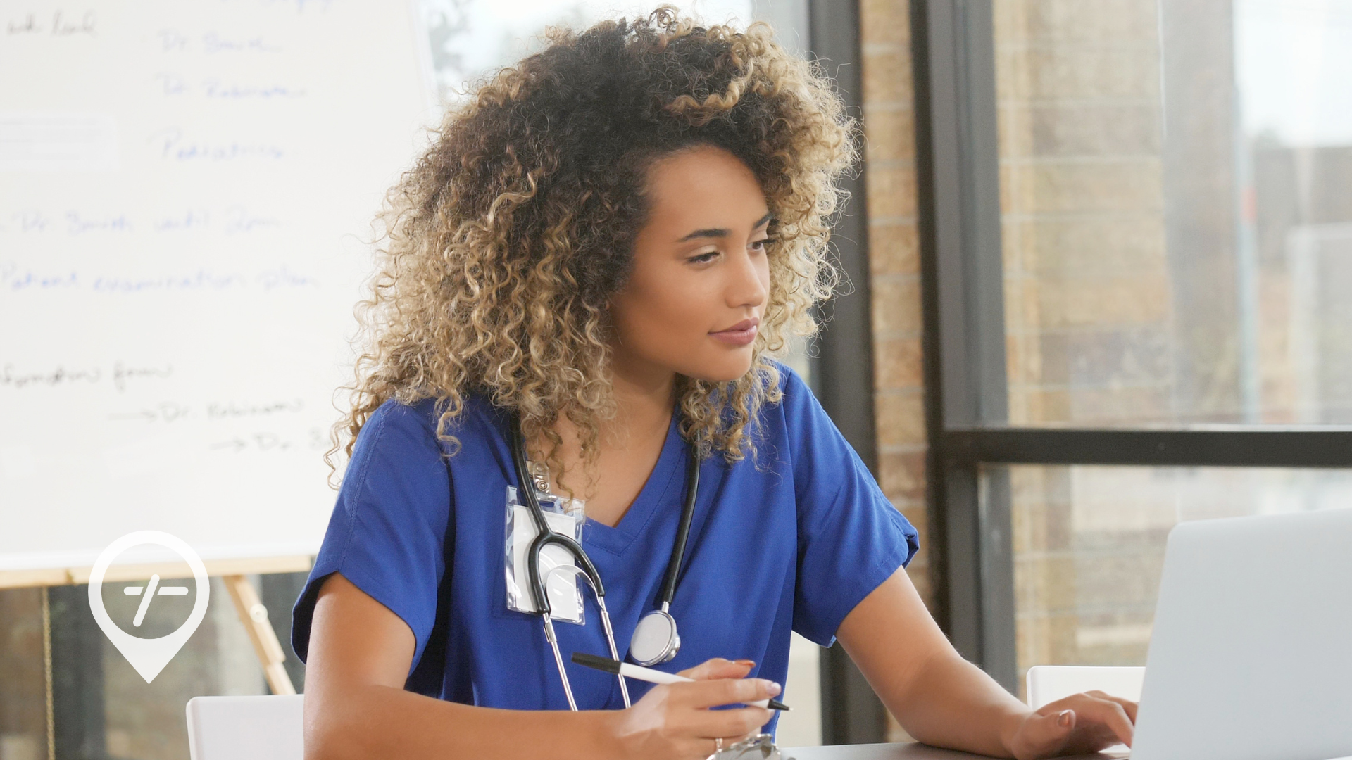A nurse sitting at a desk with her laptop reviewing her payroll taxes.