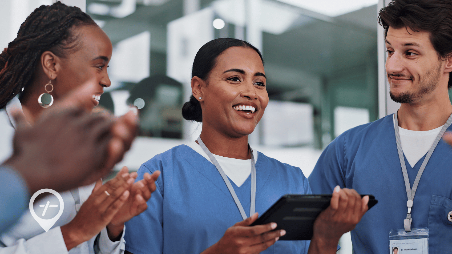 A group of nurses and healthcare administrators laughing and clapping.