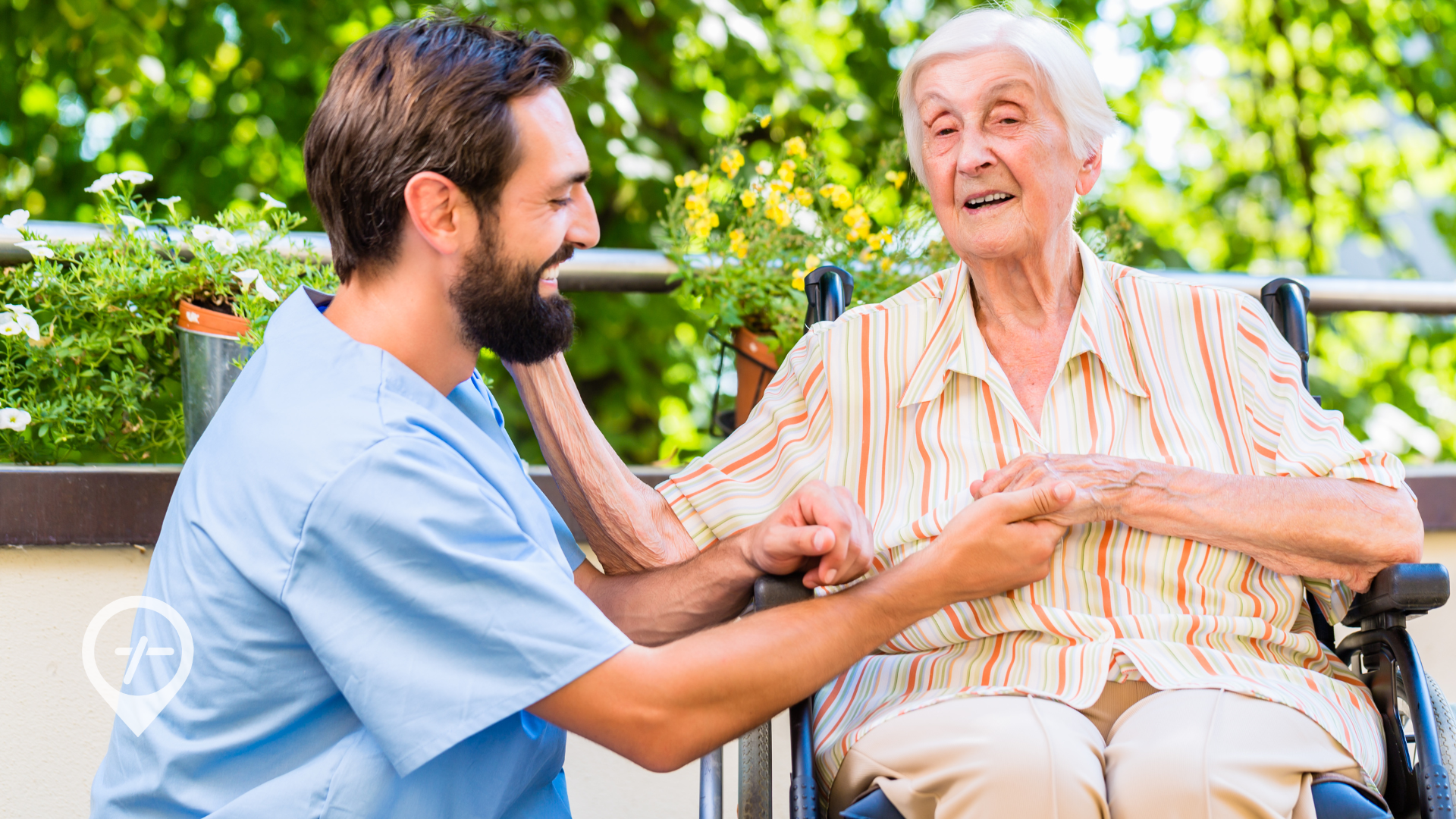 A young nurse smiles as he tends to an elderly patient in a wheelchair.