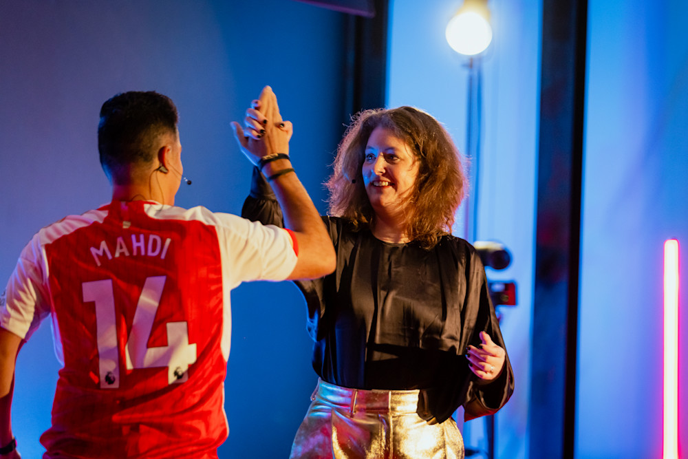 Mahdi and Anouk giving each other a high five on stage