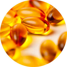 Close-up of several golden fish oil capsules scattered on a soft surface.