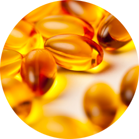  Close-up of several golden fish oil capsules scattered on a soft surface.
