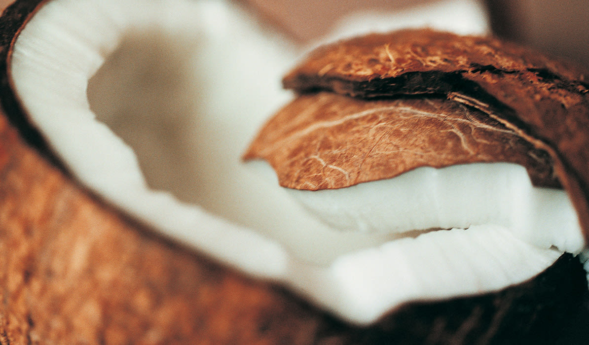 Coconut shell split open, revealing the white coconut meat inside.