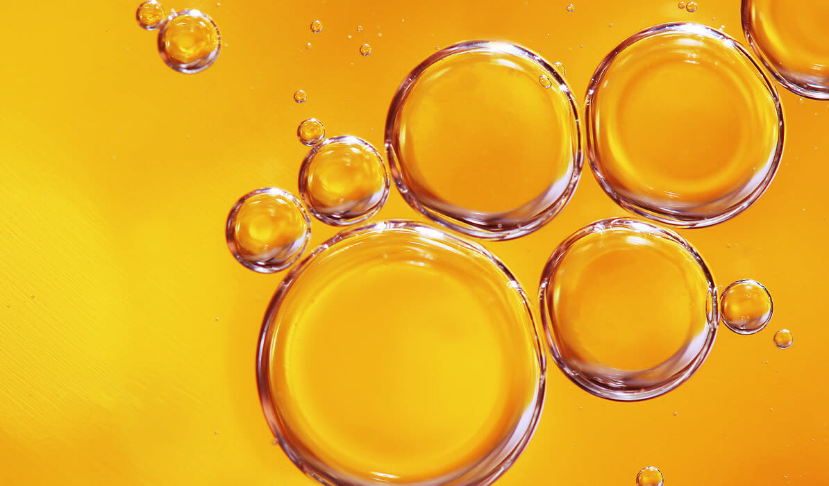 Clear fluid bubbles floating on an orange background