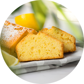  Sliced lemon cake on a plate, showcasing its moist texture and a fresh lemon.