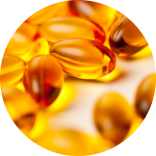 Close-up of several golden fish oil capsules scattered on a soft surface.